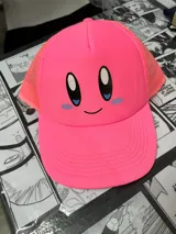 Gorro de visera rosa con malla en la parte trasera y estampado de la cara de Kirby en el frente.