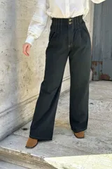 Pantalón de jean negro de corte ancho, recto y de tiro alto. Tiene elástico y pinzas en la pretina.