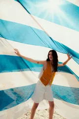 Bermuda de jean color blanco, con tiro alto y corte recto. Presenta costuras en contraste color marrón y cordón ajustable en la cintura.