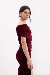 Vestido corto asimétrico de terciopelo color bordó, con diseño de un solo hombro, frunces en toda la silueta y un detalle lateral largo que aporta movimiento.