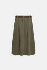 Falda midi tipo capa de tiro medio, confeccionada en mezcla de algodón color verde militar. Cuenta con cintura con trabillas, bolsillos de vivo en los laterales, cierre lateral con cremallera oculta y aplicación de cinturón marrón de estilo western con hebilla metálica grabada.