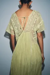 Vestido midi de Zara Woman Collection confeccionado en mezcla de viscosa color verde claro. Presenta escote cuadrado, manga corta, detalles de bordados a tono en la parte superior y falda plisada con bajo satinado.