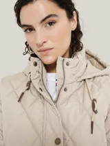 Campera acolchada color beige, con capucha y cierre de cremallera.