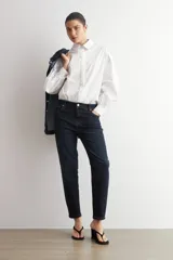Camisa blanca de corte oversize, con cuello camisero clásico y mangas largas abullonadas.