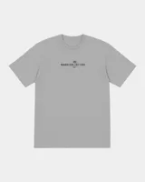 Remera gris de manga corta con corte regular, de la marca Kaboa Industries, con estampa en la espalda que presenta un esqueleto dentro de un ataúd rodeado por alas oscuras y las leyendas WAKE UP y Kaboa Industries.