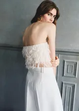 Top de diseño strapless color blanco marfil, con textura de flecos tipo plumas en todo el cuerpo y corte crop.