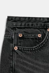 Jeans de tiro medio con diseño de cinco bolsillos y pierna ancha. Presenta un corte recto y holgado con bajo acabado sin costuras y cierre frontal con cremallera y botón metálico.