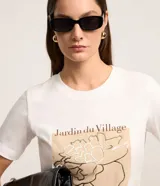 Remera Cortelle de manga corta y cuello redondo, confeccionada en algodón. Presenta un estampado frontal localizado con diseño floral y la inscripción 'Jardin du Village'.