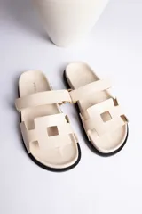 Sandalias marrones con dos tiras anchas sobre el empeine, una de ellas ajustable con hebilla dorada.