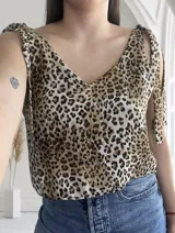 Blusa con estampado animal print, escote en V y tiras con nudo en los hombros.