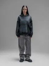 Hoodie oversize de corte crop en color gris oscuro, confeccionado en algodón rústico. Presenta un diseño con costuras expuestas, efecto de desgaste y detalles de roturas en los bordes, incluyendo puños y ruedo.