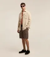 Bermuda cargo de algodón color blanco, con bolsillos laterales y traseros, cierre con botón y cremallera.