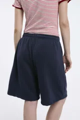 Short tipo bermuda de algodón fleece color gris claro, con cintura elastizada y bolsillos laterales.