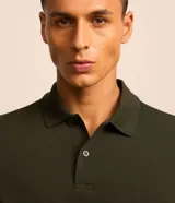 Remera polo de manga corta color verde militar, confeccionada en algodón peruano con cuello convencional y cierre de botones.