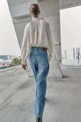 Jeans de tiro alto, color celeste claro con efecto desgastado y lavado. Modelo de corte holgado (loose baggy) con cierre frontal de botones metálicos y cinco bolsillos.