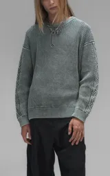 Sweater de cuello redondo con diseño de tejido texturizado en color verde y blanco. Presenta un calce relajado y terminaciones en punto rib en el cuello.