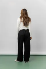 Pantalón deportivo de corte wide leg con caída relajada. Presenta cintura elastizada con cordón ajustable, bolsillos laterales y un interior frizado para mayor abrigo.