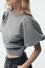 Jersey de punto de cuello redondo con mangas cortas abullonadas y acabado acanalado en el ruedo.