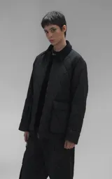 Campera oversize de microfibra opaca con diseño matelaseado de rombos. Presenta cuello de corderoy a tono, cierre frontal metálico y dos amplios bolsillos delanteros con solapa y broche snap. Interior forrado y relleno con guata térmica.