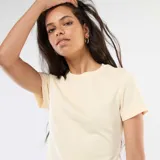 Camiseta color beige de punto de canalé fino, con cuello redondo y mangas cortas.