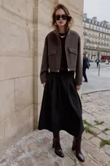 Cazadora de corte corto y diseño estructurado, confeccionada en tejido de paño color marrón. Presenta cuello subido, manga larga, bolsillos delanteros de plastrón con solapa y cierre frontal con cremallera oculta y botones a presión.