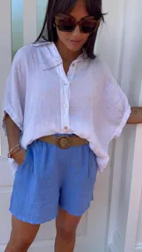 Short de lino color rojo, con cintura elástica y cinturón de rafia con hebilla circular.