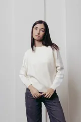 Sweater color crema de punto con cuello redondo y mangas largas con paneles de lentejuelas plateadas.