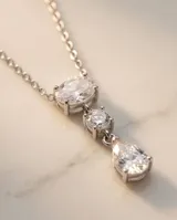 Collar de acero con colgante de tres circonias: una ovalada en la parte superior, una pequeña redonda en el centro y una circonia en forma de lágrima en la base.