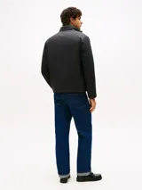 Campera acolchada negra, con cuello alto y cierre frontal de cremallera. Presenta bolsillos laterales con cierre y el logo de Tommy Hilfiger bordado en el pecho.