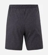 Pijama corto masculino confeccionado en algodón, compuesto por una remera lisa de manga corta con cuello redondo en color gris melange y una bermuda con estampado integral a cuadros oscuros con cintura elástica.