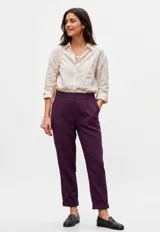 Pantalón de corte recto y tiro alto, color violeta, con cintura elástica, pinzas frontales y ruedo con dobladillo.