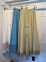 Pantalón palazzo celeste con cintura elastizada y cordón ajustable. Estampado de figuras geométricas en el ruedo.