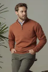 Buzo liso de punto fino en hilo de algodón color naranja, con cuello alto y cierre frontal parcial con detalle de cuero.