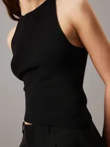 Top sin mangas negro de punto de rayón suave con sutil efecto brillante y bajo asimétrico. Diseño con espalda cruzada y bordado de Calvin Klein en la misma gama de tonos en el bajo.