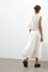 Top blanco de algodón con cuello redondo y sin mangas. Presenta bordados a tono y cierre trasero con abertura y botón.