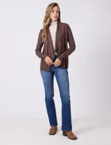 Cardigan de tejido liviano color marrón, con frente abierto, mangas largas entalladas con puños de rib y detalle de botones en la espalda.