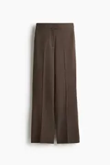 Pantalón de corte bootcut con estampado de pata de gallo en tonos marrones. Presenta cierre frontal con pretina prolongada, botón oculto y corchetes, además de raya marcada en la parte delantera y trasera, bolsillos laterales al bies y bolsillos traseros ribeteados.