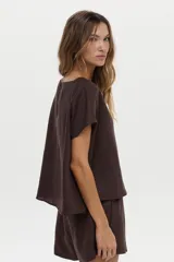 Blusa de lino color blanco, con cuello bote y mangas cortas de corte holgado.