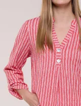 Blusa holgada de color verde con diseño de rayas verticales blancas, escote en V con cuello mao y pechera corta con botones. Mangas tres cuartos regulables y bajo redondeado.