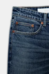 Jeans de denim azul oscuro con efecto desgastado y lavado, tiro bajo, corte bootcut y bajo flare. Presenta cinco bolsillos y cierre frontal con cremallera y botón.