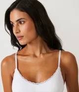 Soutien blanco de microfibra, estilo top alargado, con encaje en el escote, sin costuras, sin aro y con copas removibles.