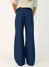 Pantalon de jean negro de corte wide leg, con tiro alto, cierre frontal con botón y bolsillos laterales.