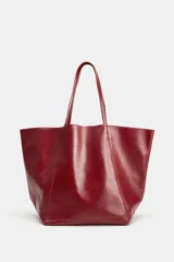 Bolso tipo shopper de cuero en color bordó, con diseño amplio y asas largas para el hombro.