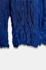 Jersey de cuello redondo y manga larga color azul, con tejido semitransparente de efecto arrugado.