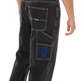 Pantalon tipo carpenter de corte holgado, color negro con costuras en contraste. Cuenta con bolsillos laterales y traseros, y detalle de logo bordado en azul en el bolsillo delantero.