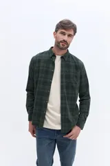 Camisa de manga larga confeccionada en viyela de algodón con diseño a cuadros en tonos verde oscuro. Presenta cuello clásico, cierre frontal con botones y bolsillo aplicado en el pecho.