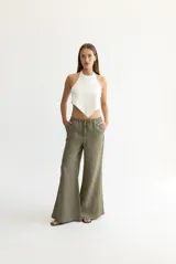 Pantalón color beige de lino, con elástico y tira ajustable en la cintura, bolsillos a ambos lados y pata de elefante estilo Oxford.