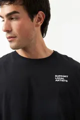 Remera unisex de manga corta, color marrón topo, con cuello redondo y texto pequeño en el pecho izquierdo que dice "SUPPORT LOCAL ARTISTS".