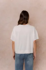 Remera negra de corte oversize con cuello redondo, mangas cortas amplias, hombros caídos y recortes delanteros.
