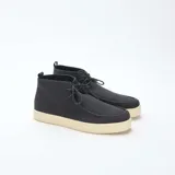 Zapatos tipo chukka de corte casual, con capellada en color negro y suela de goma en tono crema. Presentan cierre mediante cordones y una costura distintiva en la puntera.